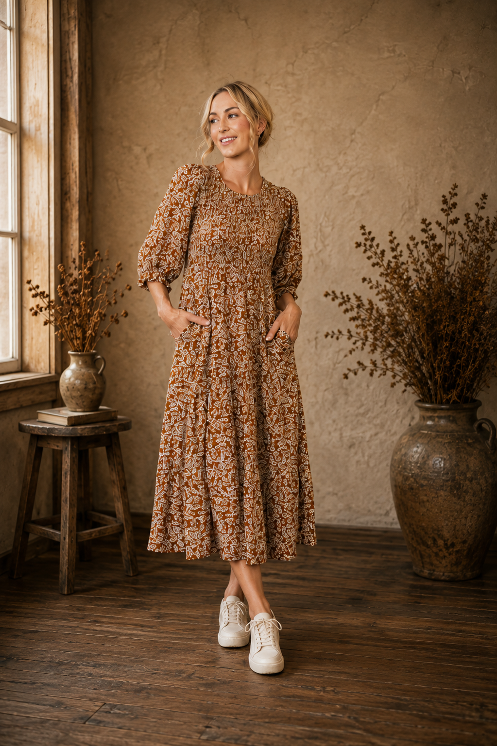 The Founder’s Dress, a copper floral midi dress with a smocked bodice, three-quarter sleeves, pockets and tiered skirt.